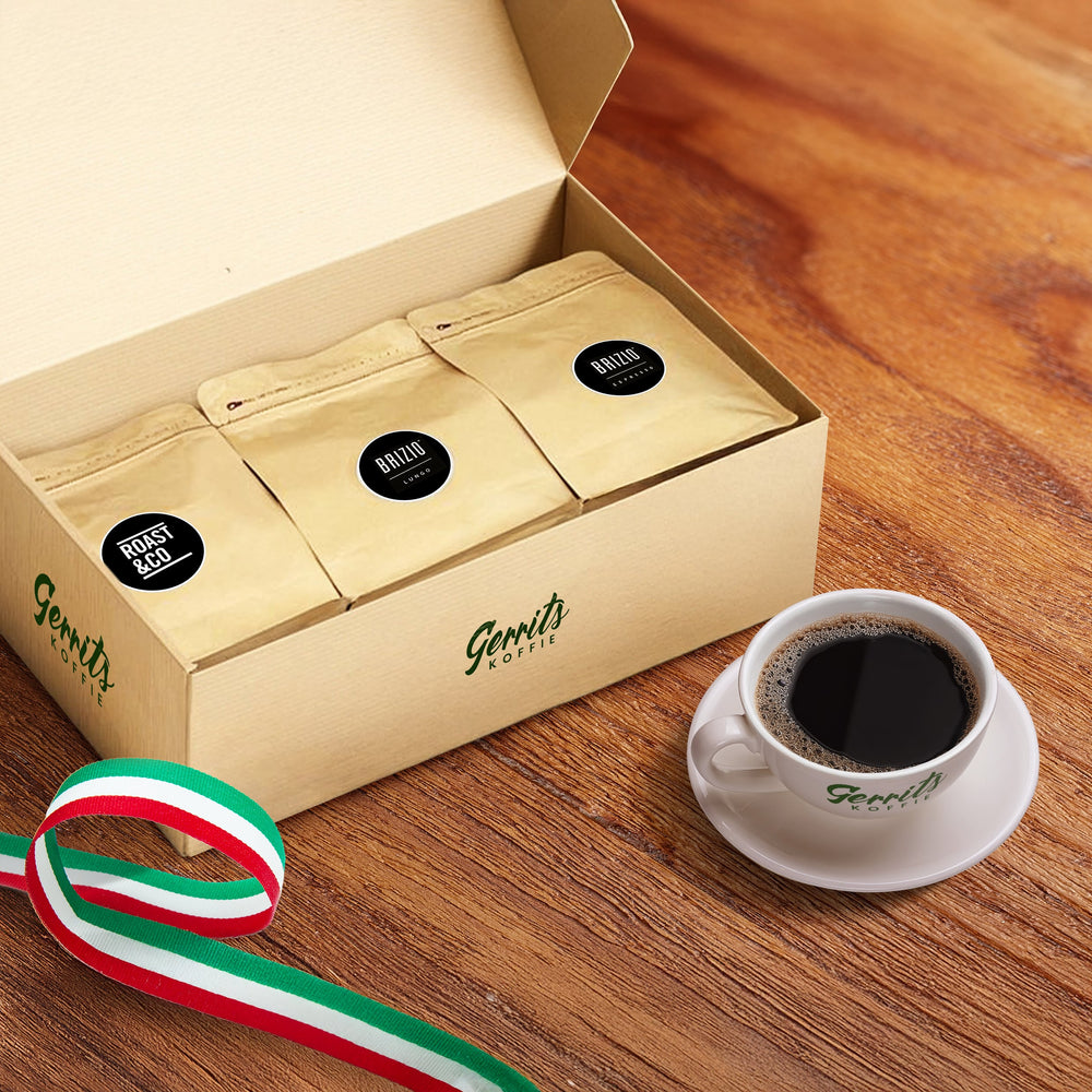 Italiaans proefpakket met drie zakjes koffie in een doos, kopje vers gezette koffie en Italiaanse lintdecoratie op houten tafel