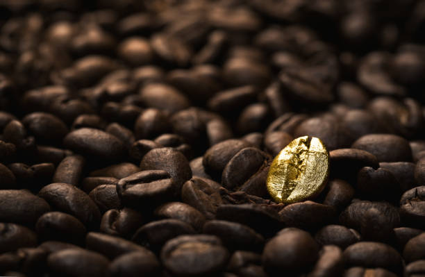 Donkere koffiebonen met een opvallende gouden koffieboon in het midden.